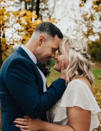 Braut und Bräutigam halten sich innig im Arm bei herbstlicher Hochzeit im Freien