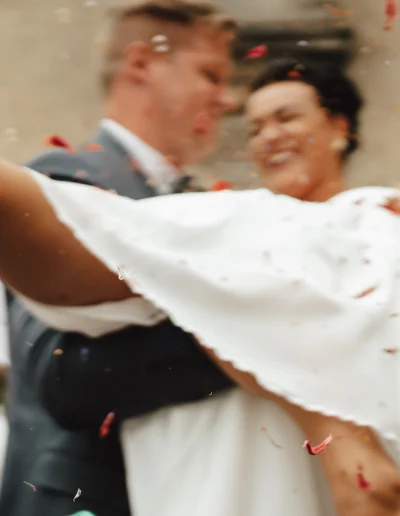 Bräutigam trägt seine Braut durch den Konfettiregen – emotionaler und ausgelassener Moment der Hochzeitsfeier