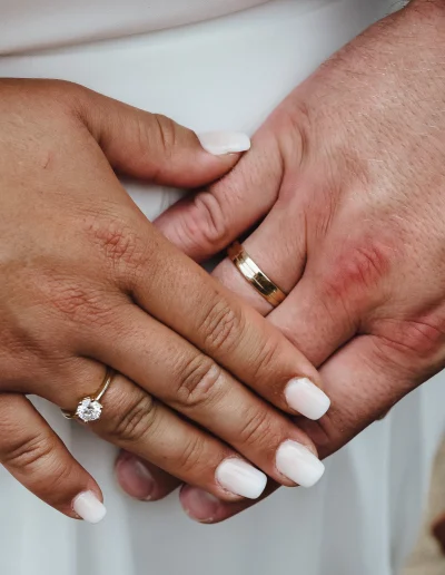 Nahaufnahme von Braut- und Bräutigam-Händen mit Eheringen und Verlobungsring – Symbol der Liebe