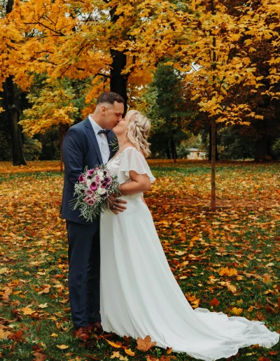 Brautpaar küsst sich im herbstlichen Park unter bunten Blättern – romantische Hochzeitsfotografie in Leipzig Halle Berlin Wittenberg